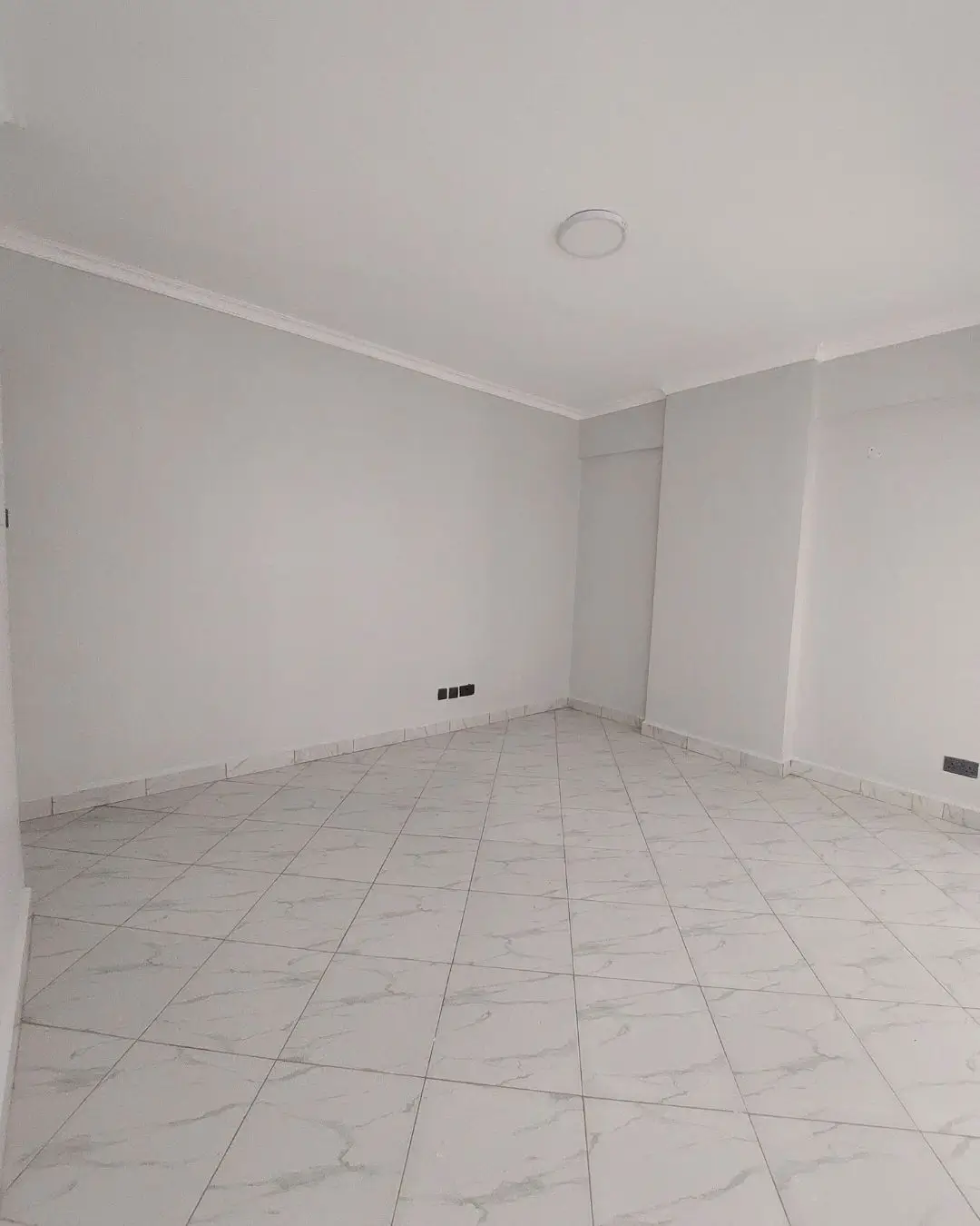 Empty room with tiled flooring, minimal fixtures visible