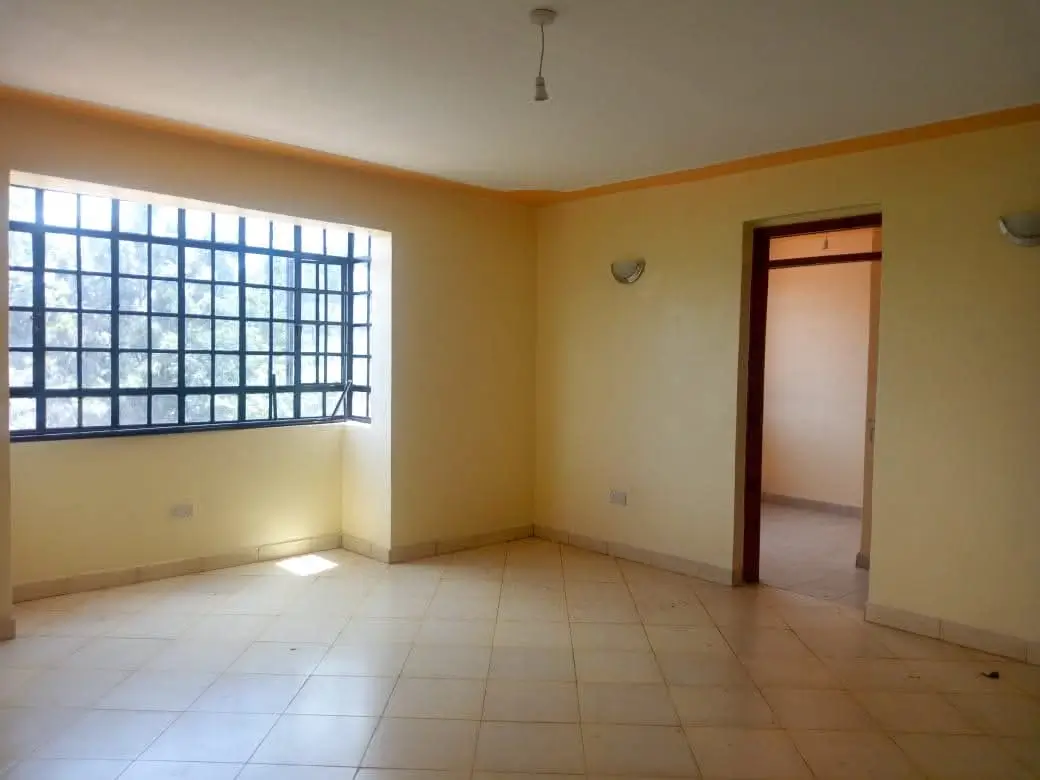 Bright living room with large window and ceramic tile flooring
