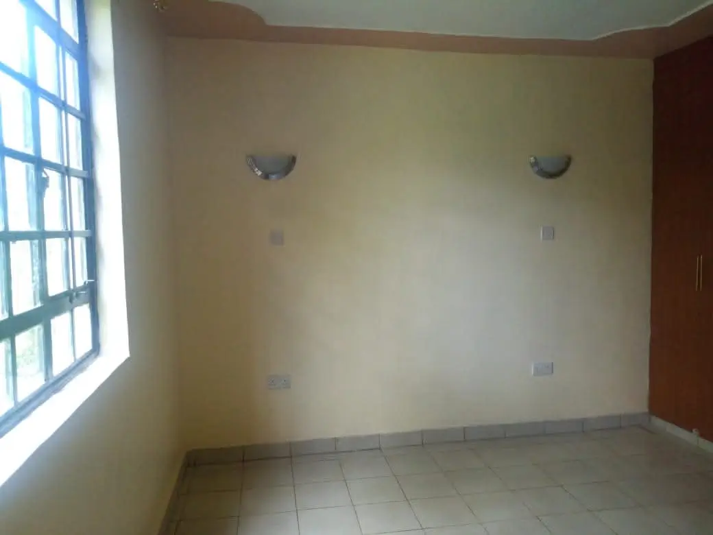 Empty bedroom with barred window and minimal fixtures