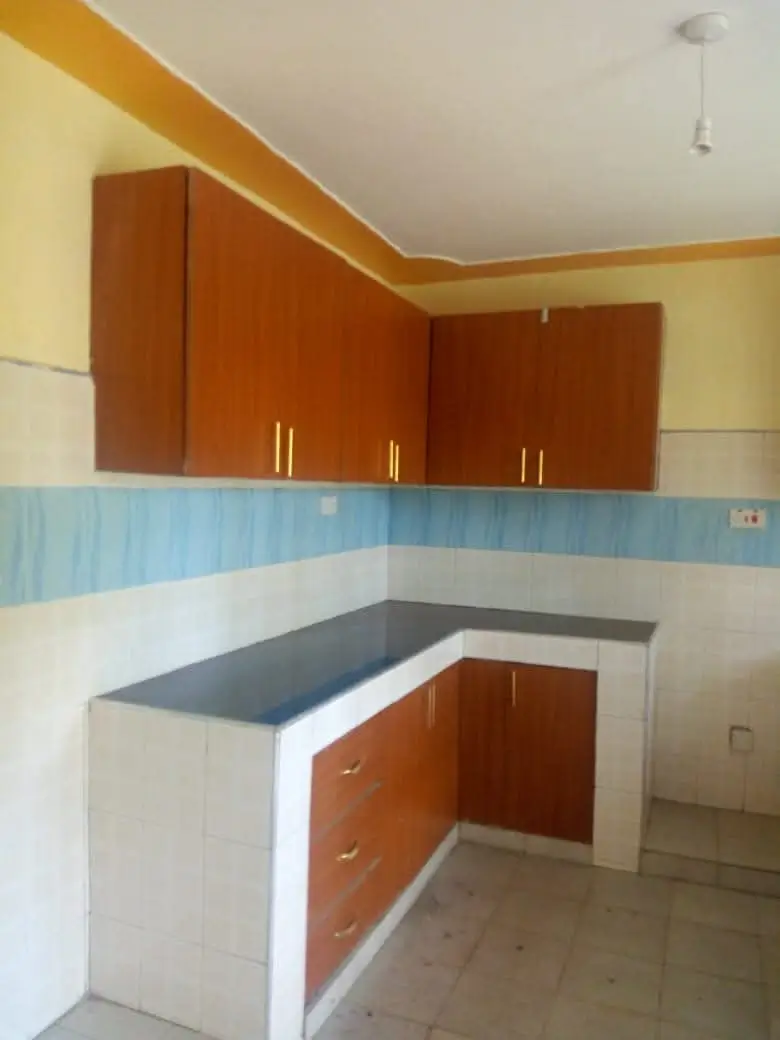 Corner kitchen with orange cabinets and dark countertops