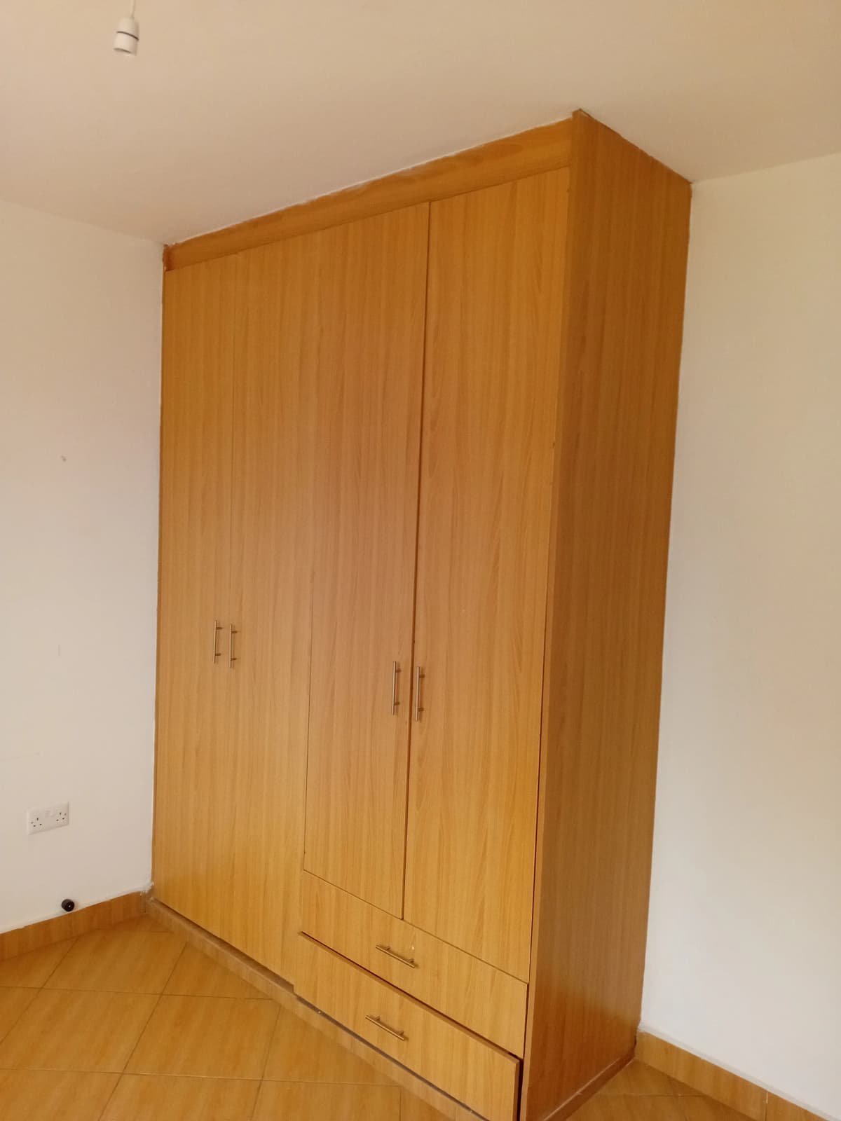 Wooden wardrobe in bedroom corner with laminate flooring