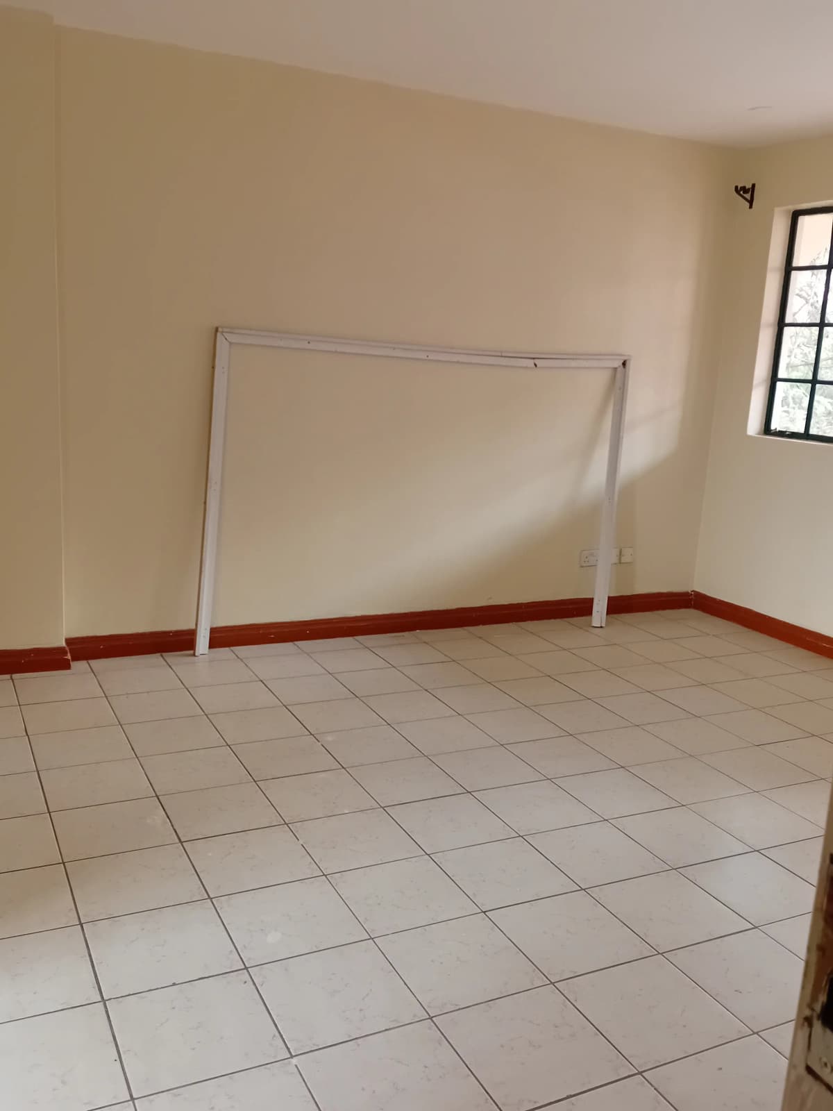 Empty room with tiled floor and red accent stripe