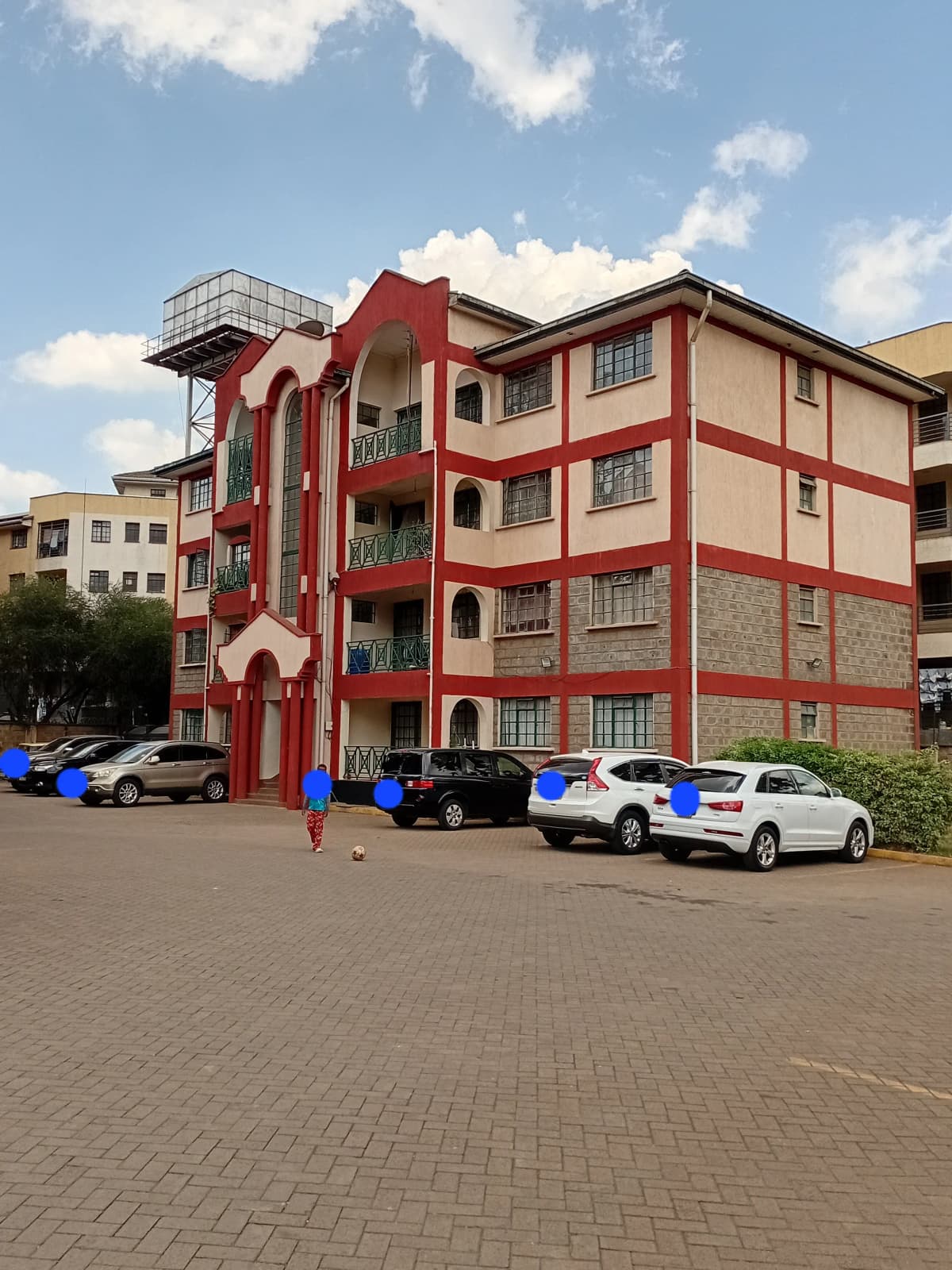 Red and cream residential building facade with parking lot