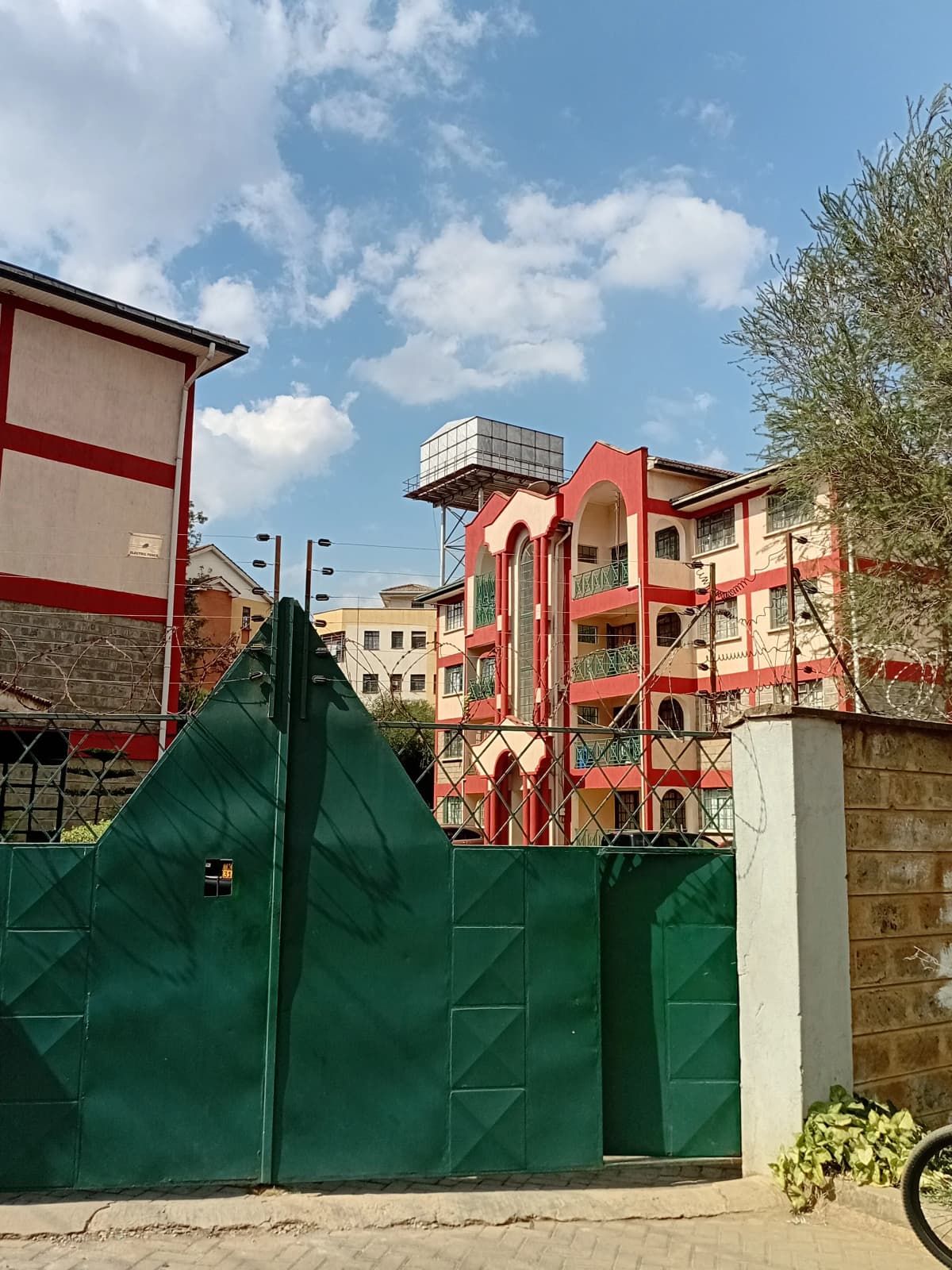 Building facade with green gate and compound entrance