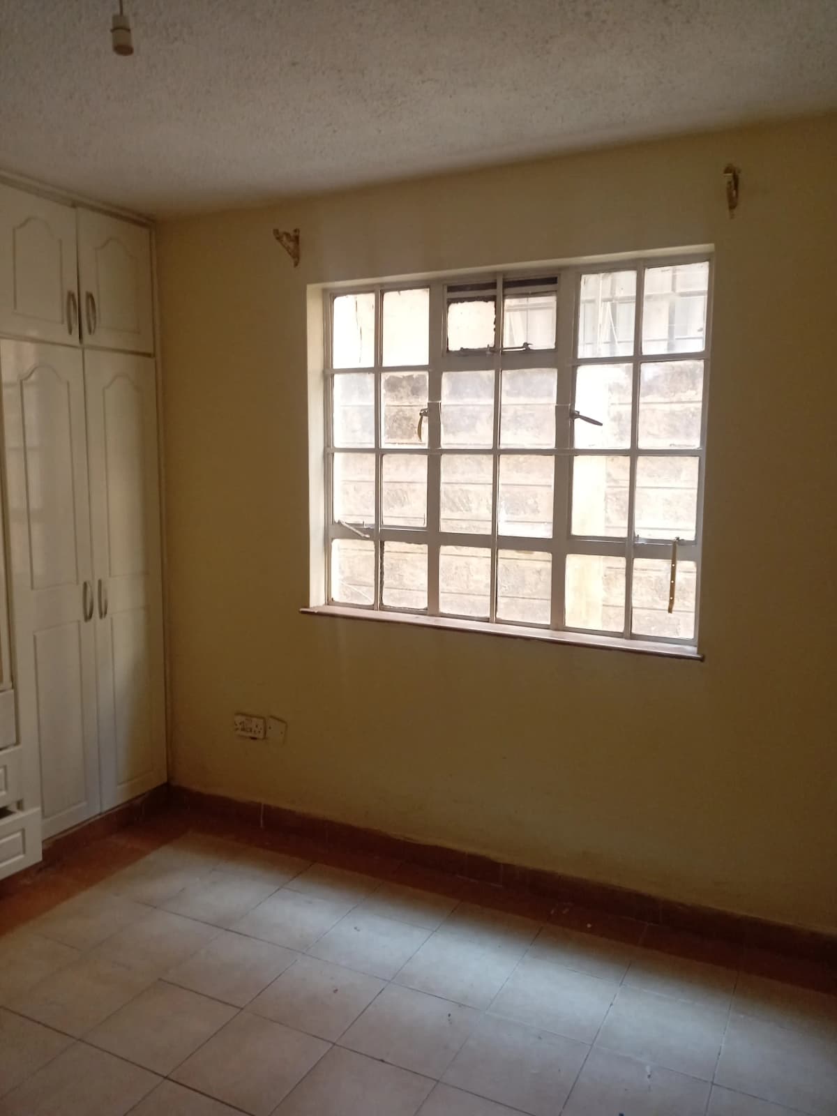 Spacious bedroom with large window and built-in wardrobe