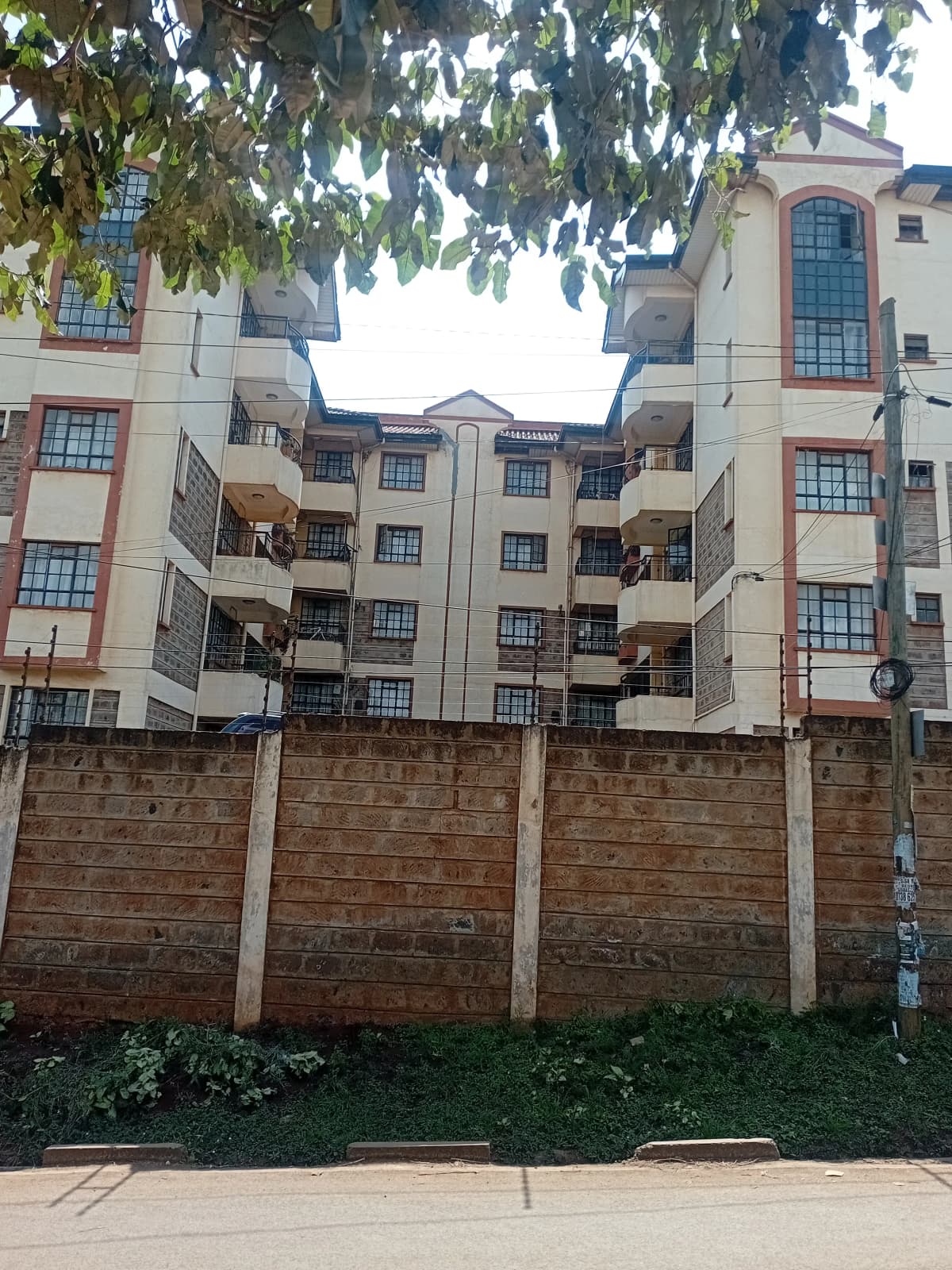 Multi-story residential building facade with brick perimeter wall