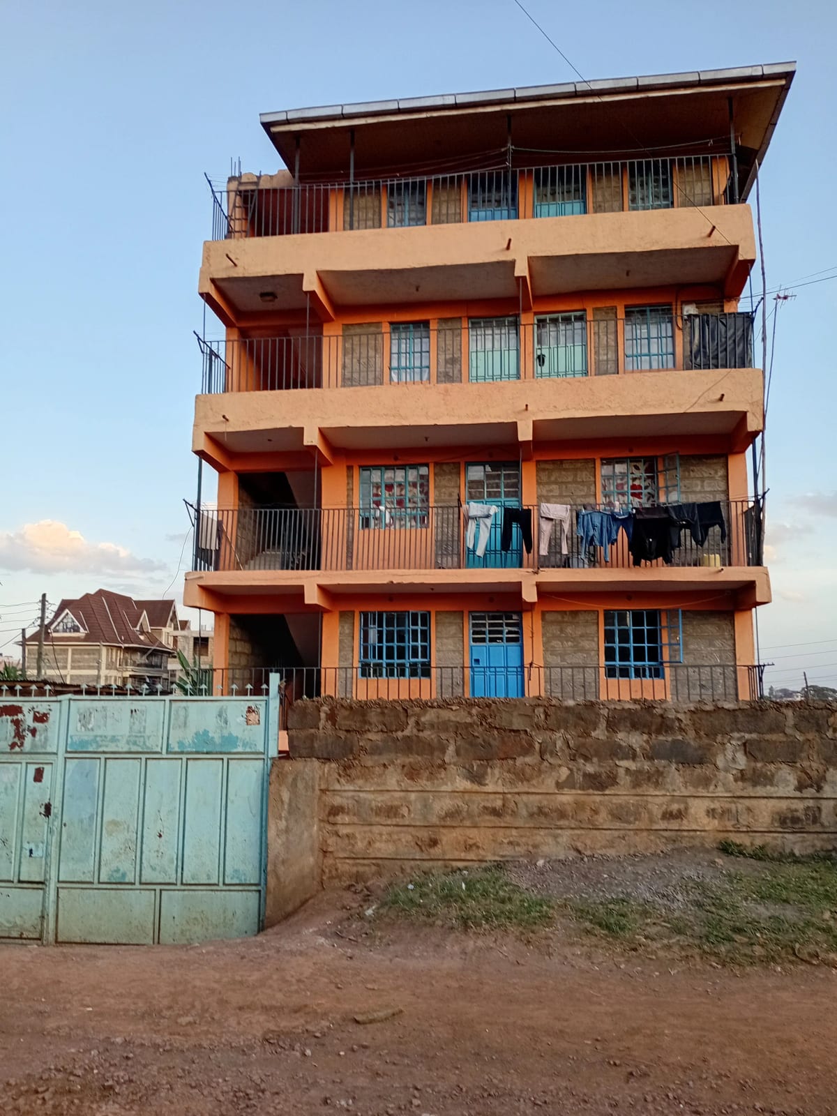 Multi-story residential building facade with balconies and gate