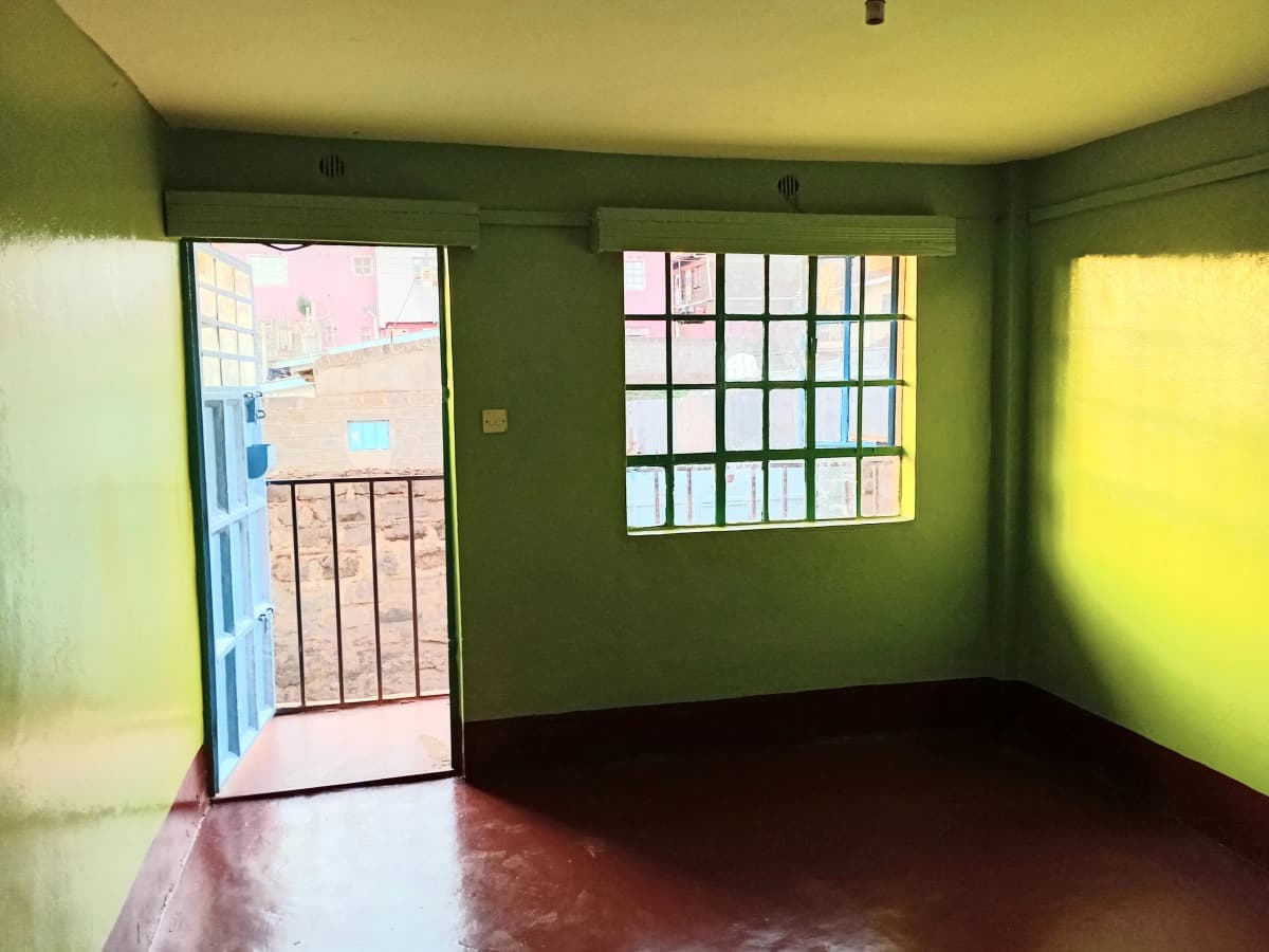 Bright green bedroom with balcony access and natural light