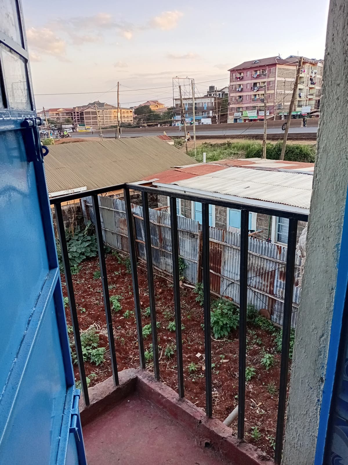 Small balcony with metal railing overlooking urban street