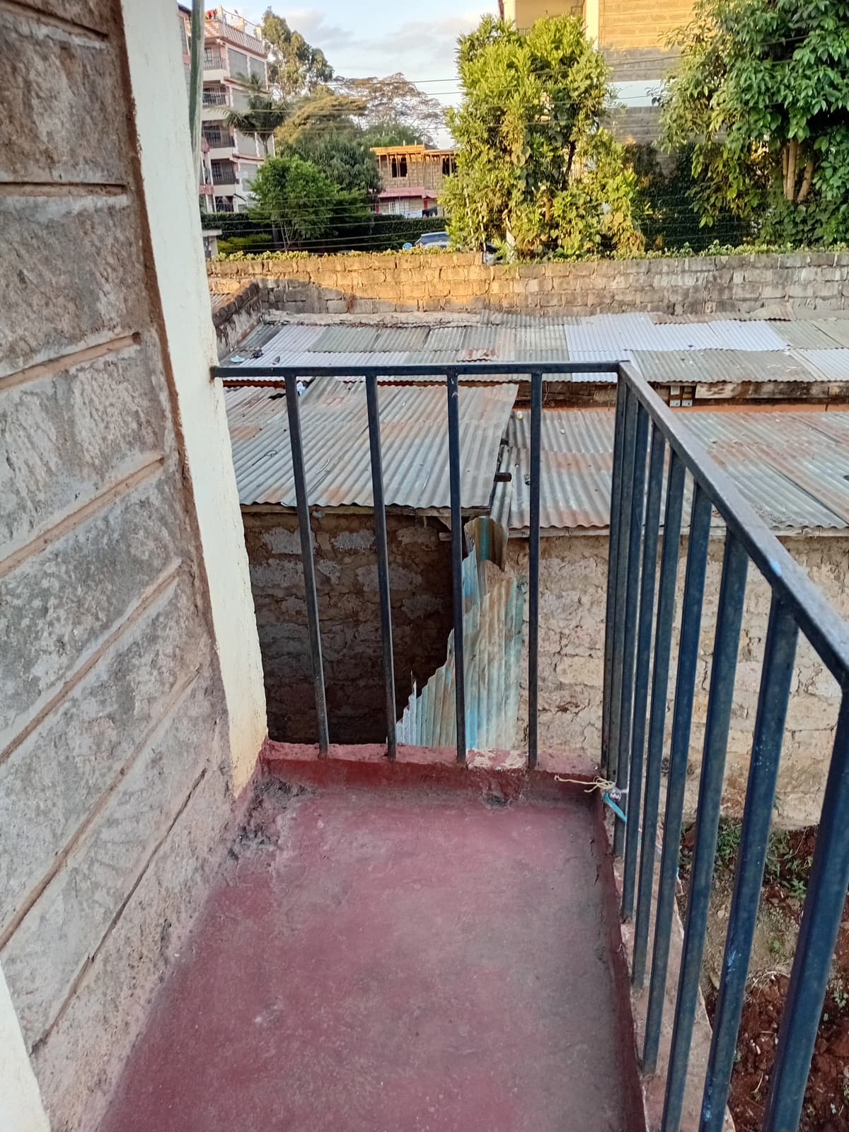 Compact balcony with metal railings and compound view