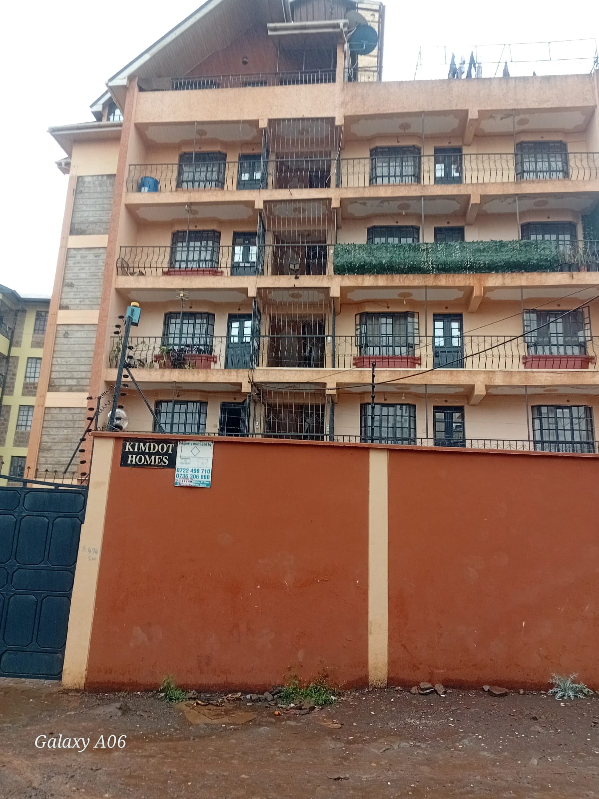 Multi-story residential building with orange perimeter wall and balconies