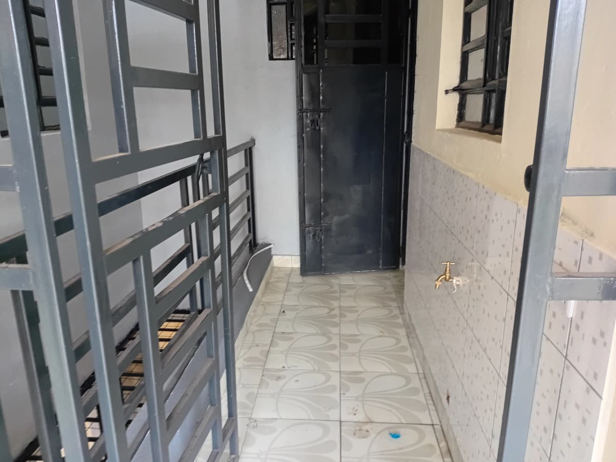 Building entrance corridor with tiled flooring and metal gates