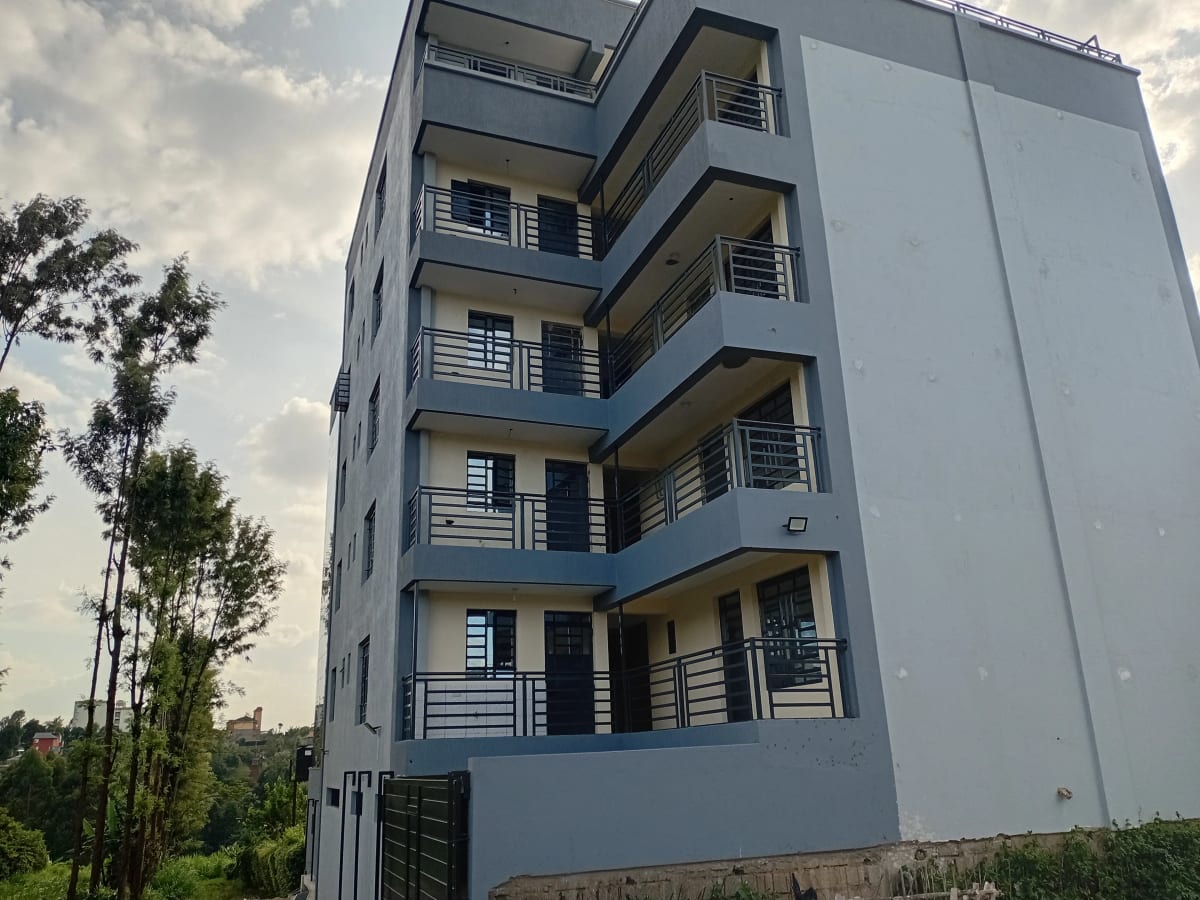 Modern multi-story residential building with blue facade and balconies