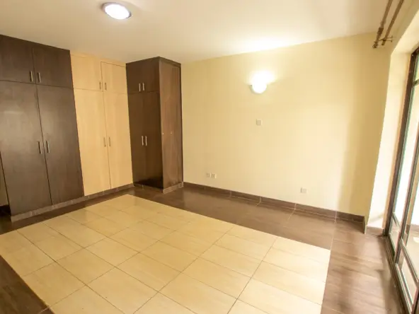 Spacious bedroom with built-in wardrobes and tiled flooring