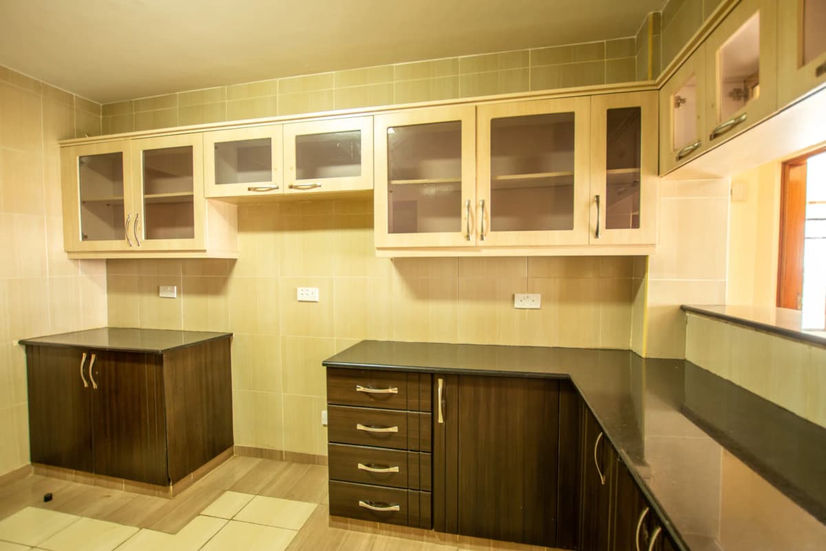 Spacious kitchen with dark wood cabinetry and glass-fronted upper storage