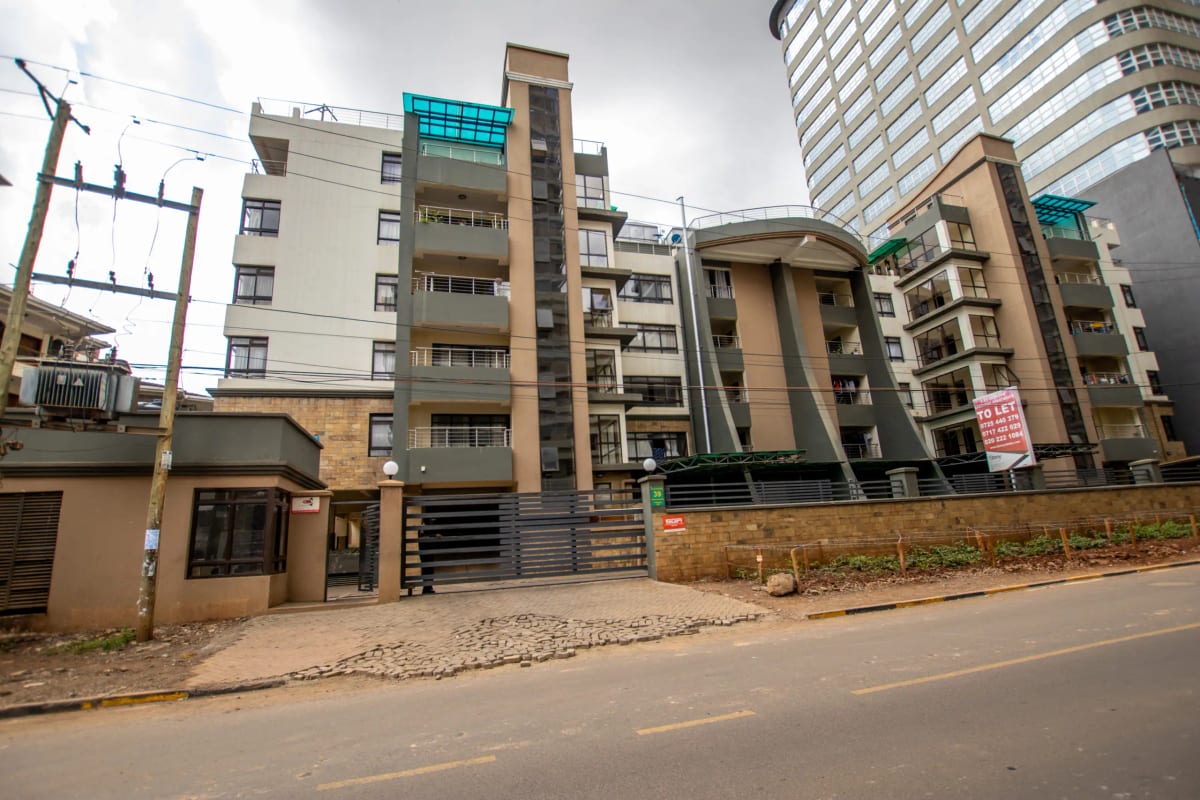 Multi-story residential buildings with gated compound entrance
