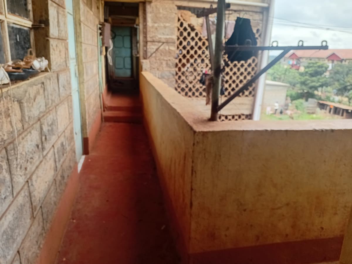 Narrow covered balcony with lattice railings and countryside view