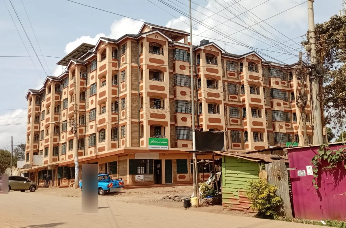 Multi-story residential apartment building with tan and orange facade