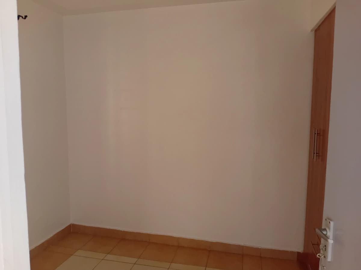 Empty bedroom with wooden flooring and neutral walls