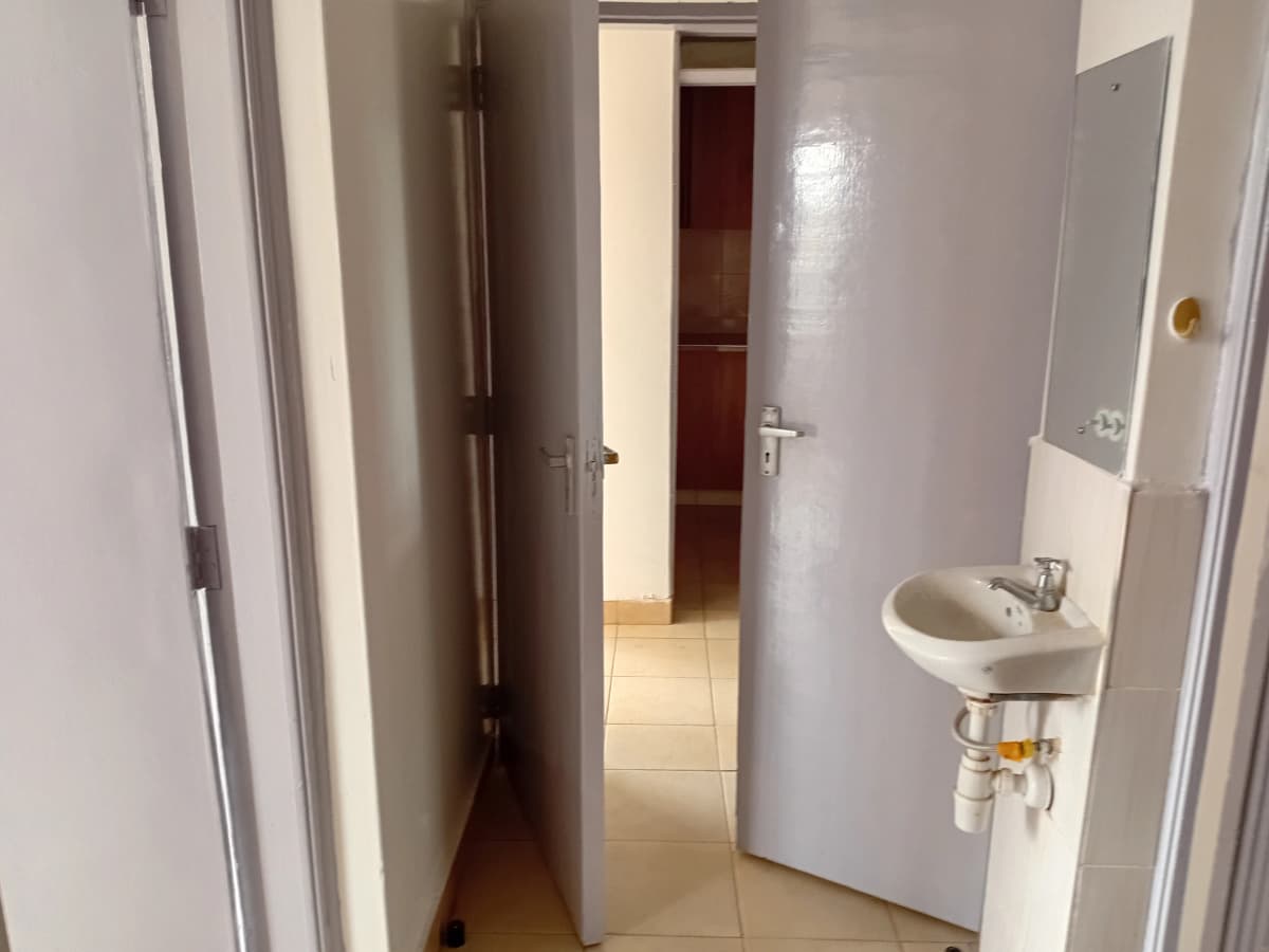 Small bathroom with wall-mounted sink and tiled flooring
