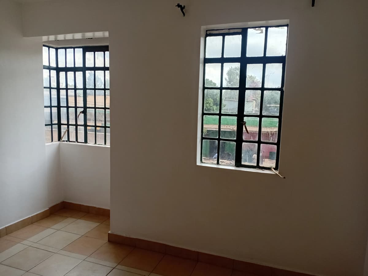 Bright bedroom with barred windows and terracotta tile floor