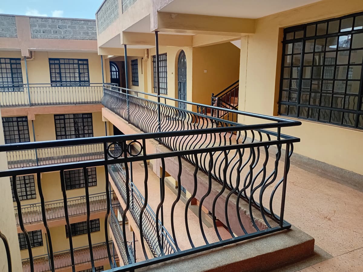 Multi-level balcony with decorative metal railings overlooking courtyard