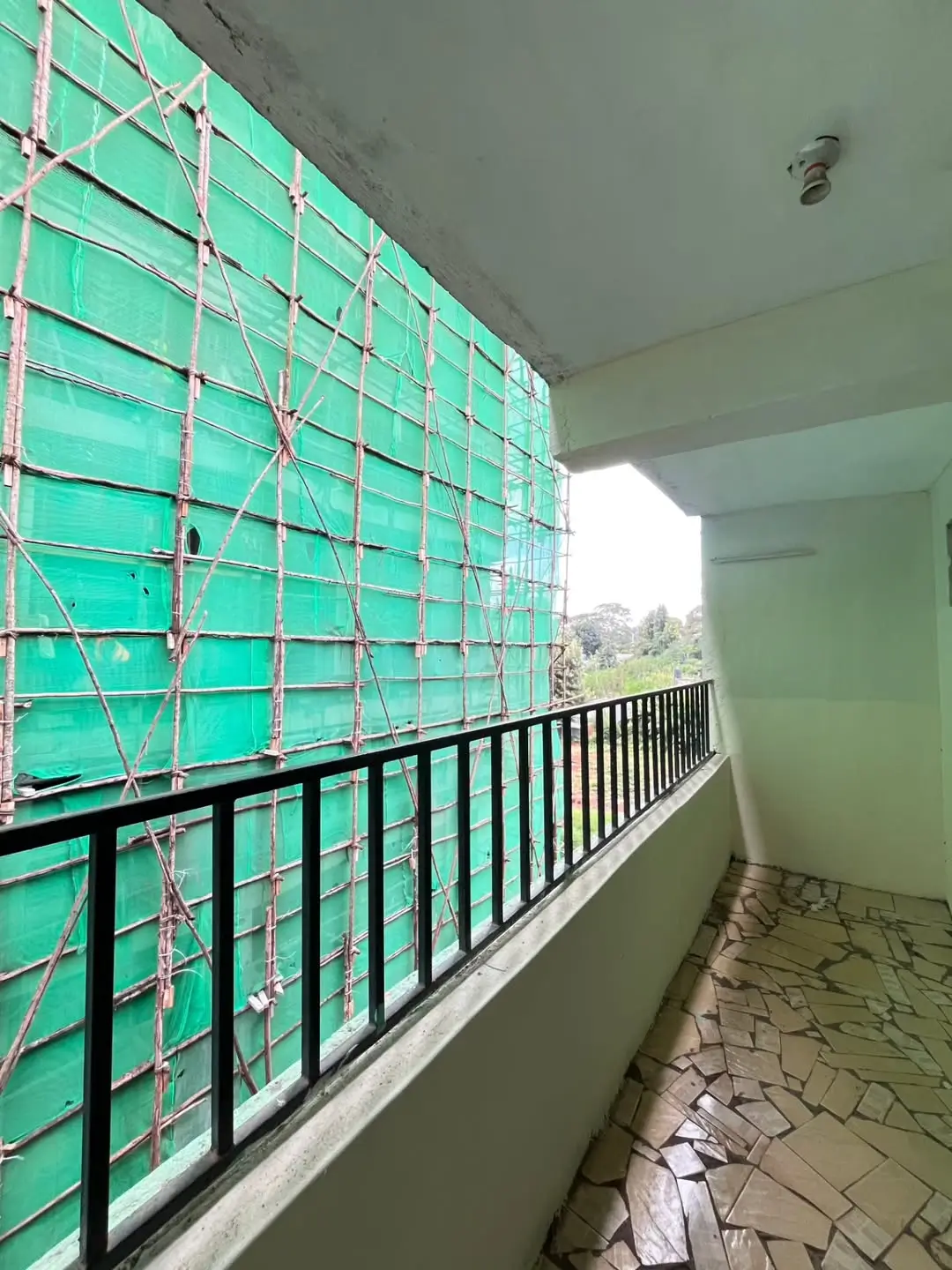 Balcony with green safety netting and distant landscape view