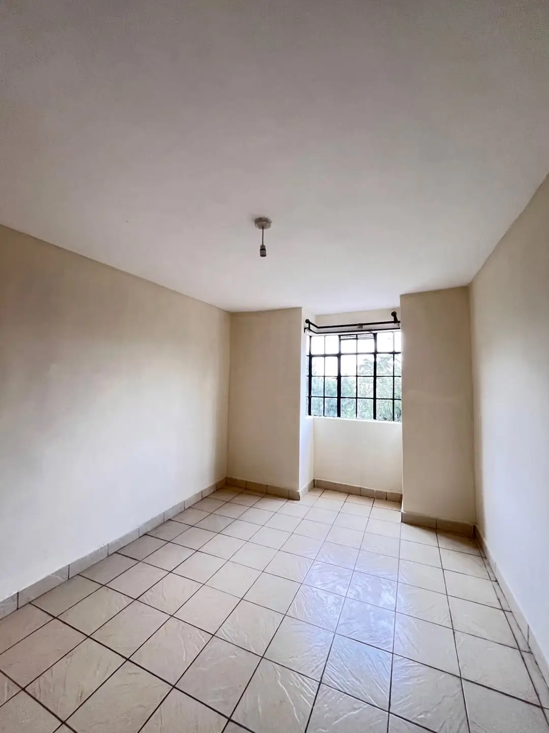 Unfurnished bedroom with tiled floor and window