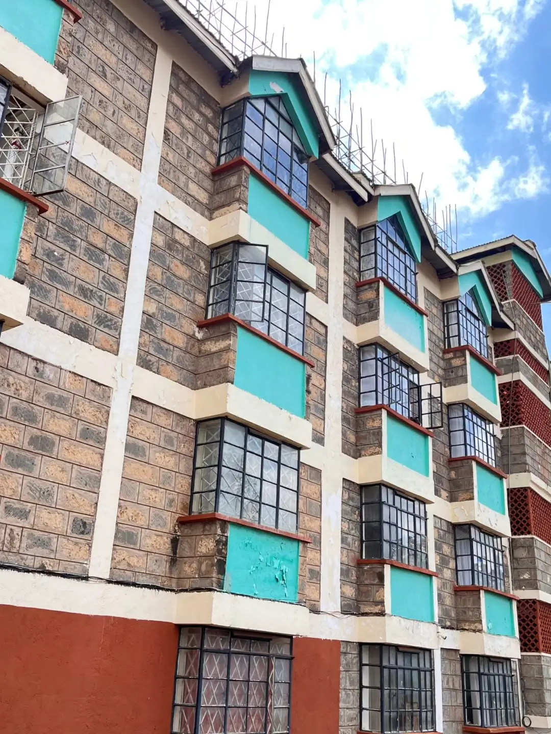 Multi-story residential building facade with turquoise accents