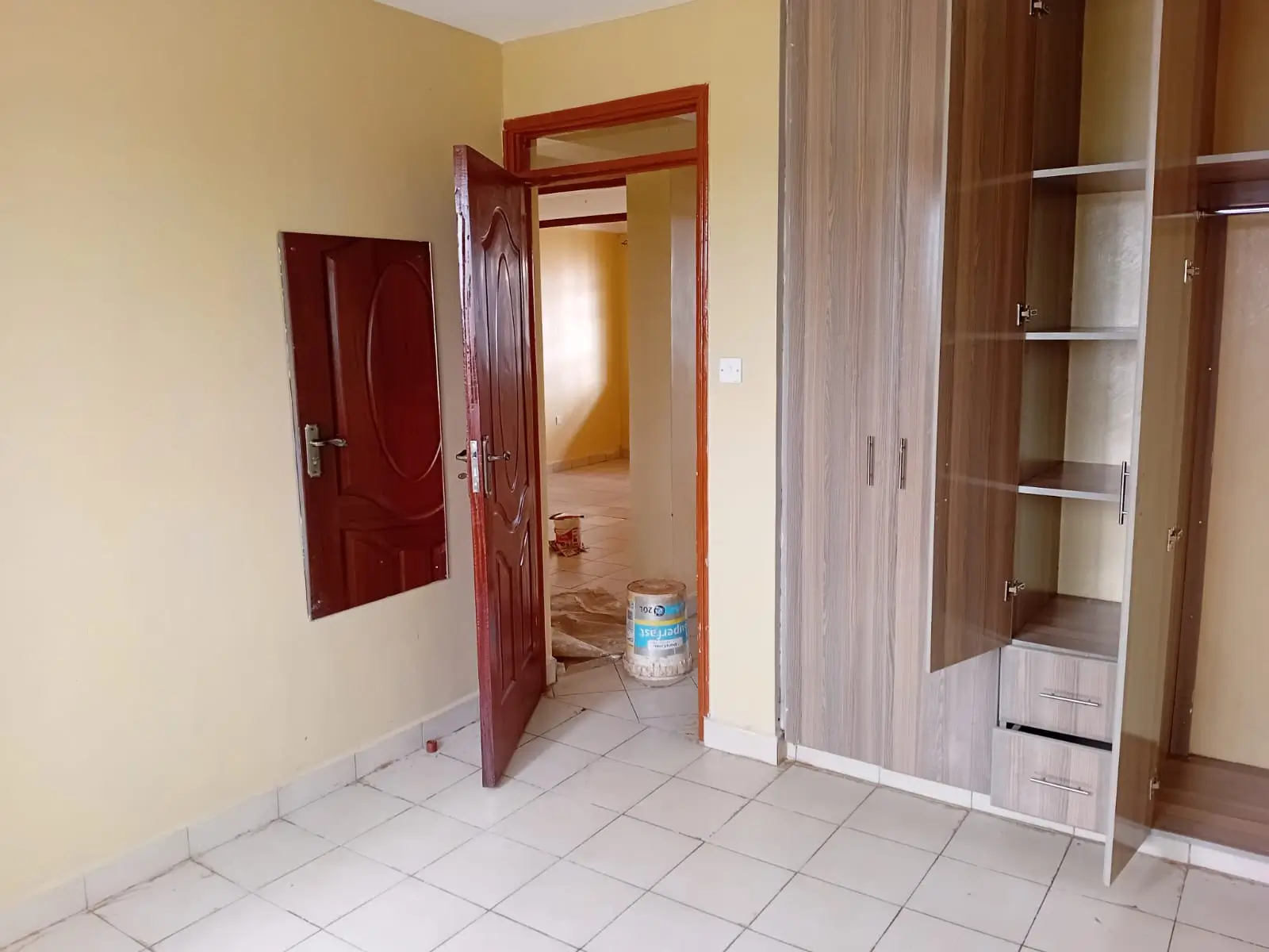 Unfurnished bedroom with built-in wardrobe and tile flooring