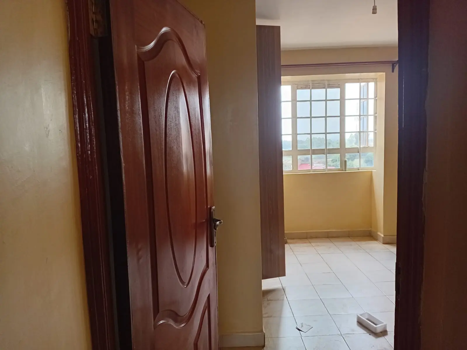 Hallway with wooden door and bright corner window