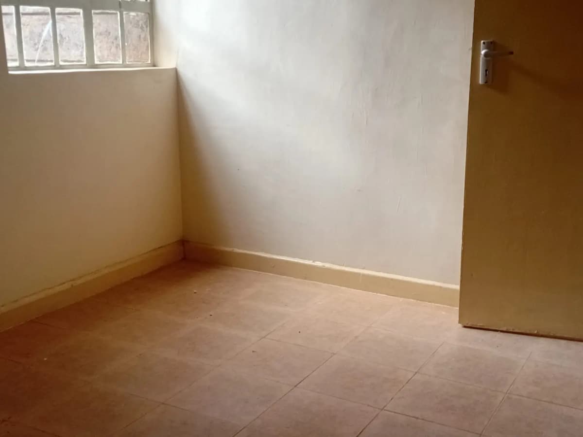 Empty bedroom with terracotta tiles and natural light