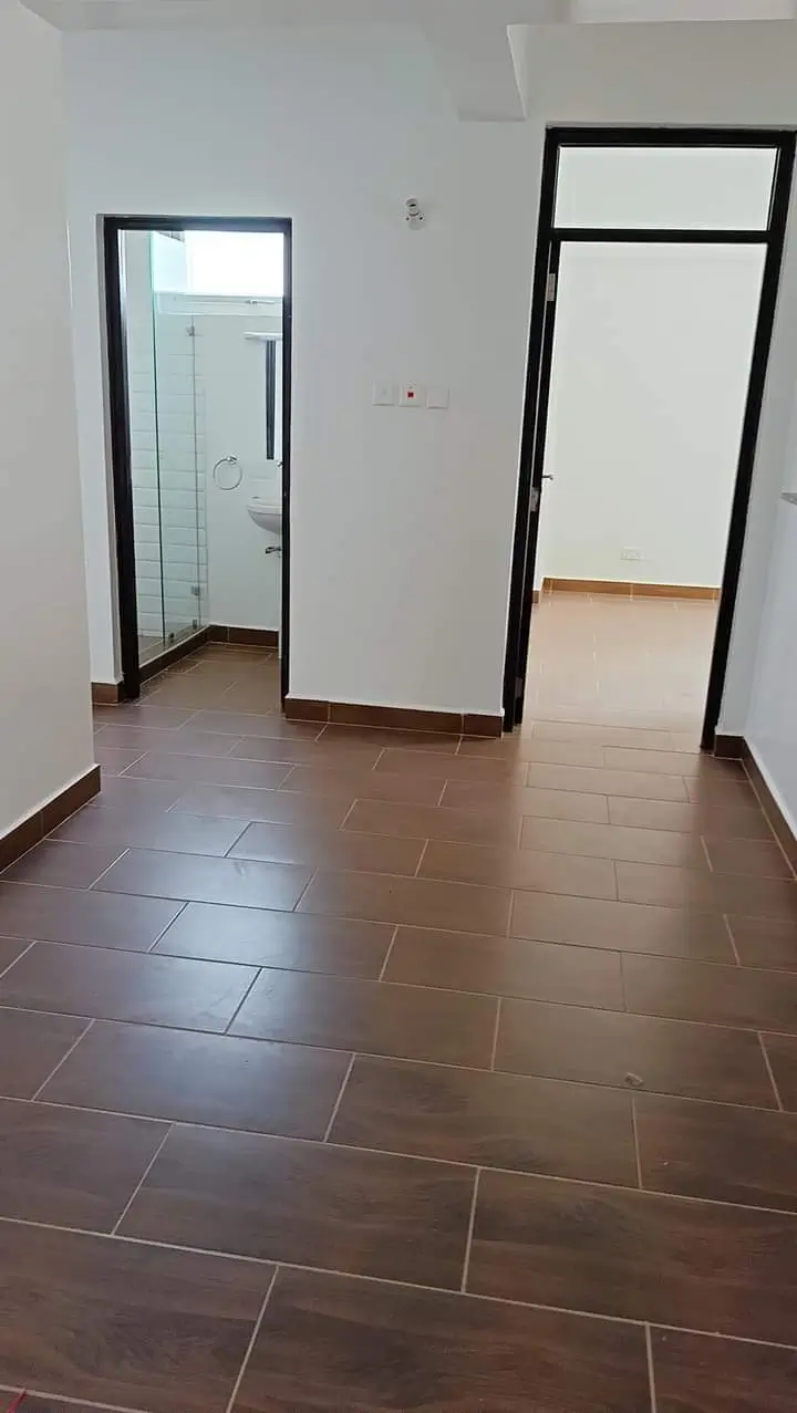 Bedroom with ensuite bathroom, dark tile flooring