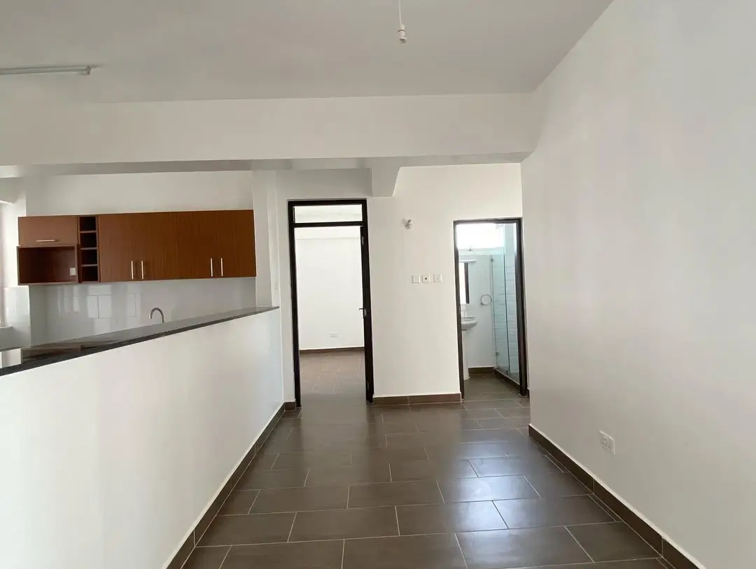 Open-plan living and kitchen area with dark tile flooring