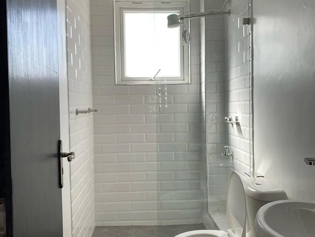 Modern bathroom with white subway tile, glass shower enclosure