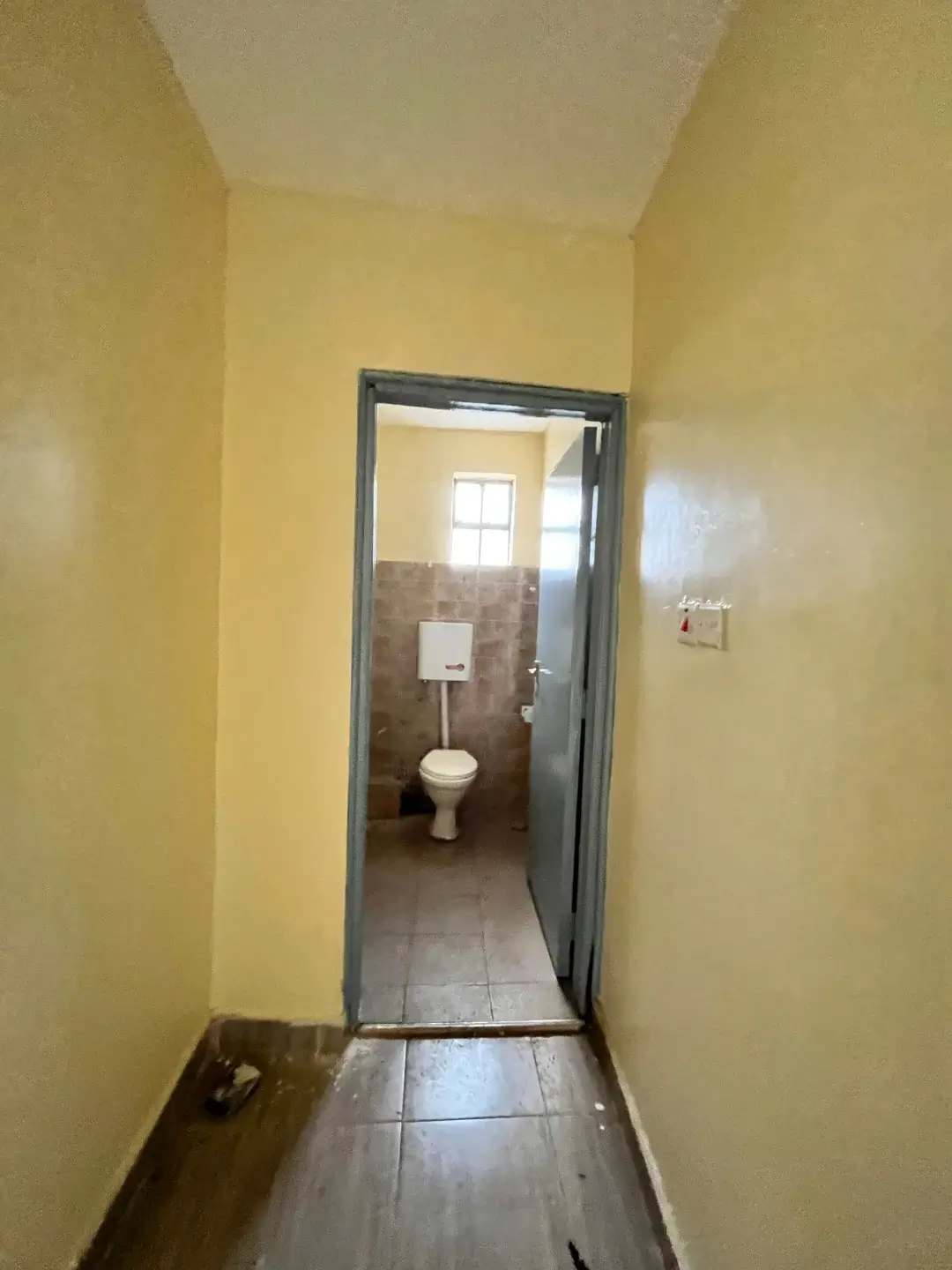 Simple bathroom with toilet and tiled flooring
