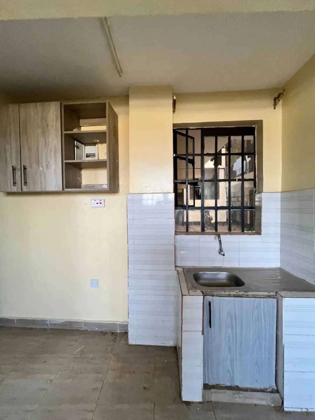 Compact kitchen with sink, storage cabinets, and tiled walls