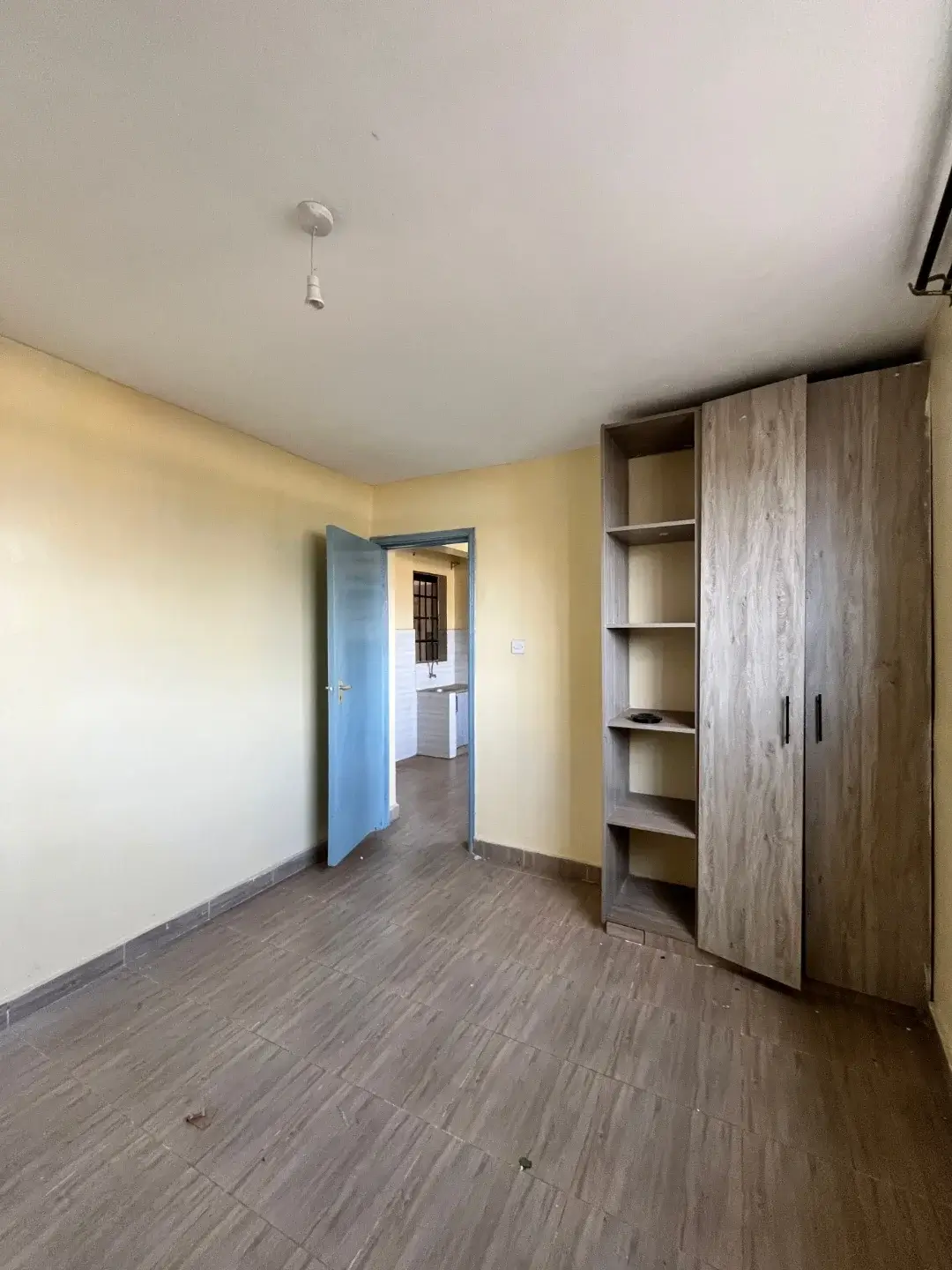 Spacious bedroom with built-in wooden wardrobes and yellow walls