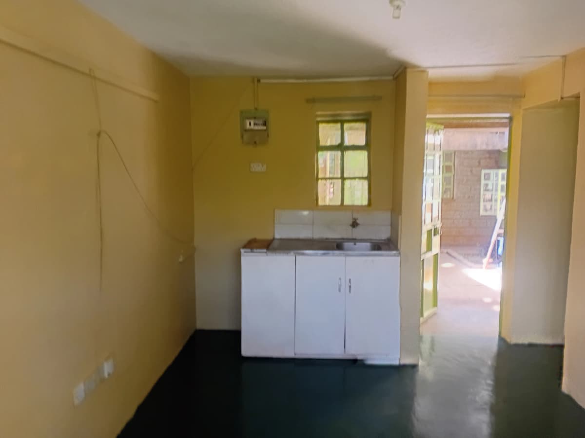 Compact kitchen with white cabinetry, yellow walls, natural light