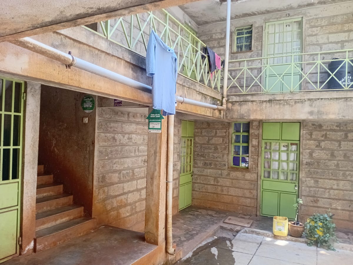 Ground floor courtyard with brick walls and green doors