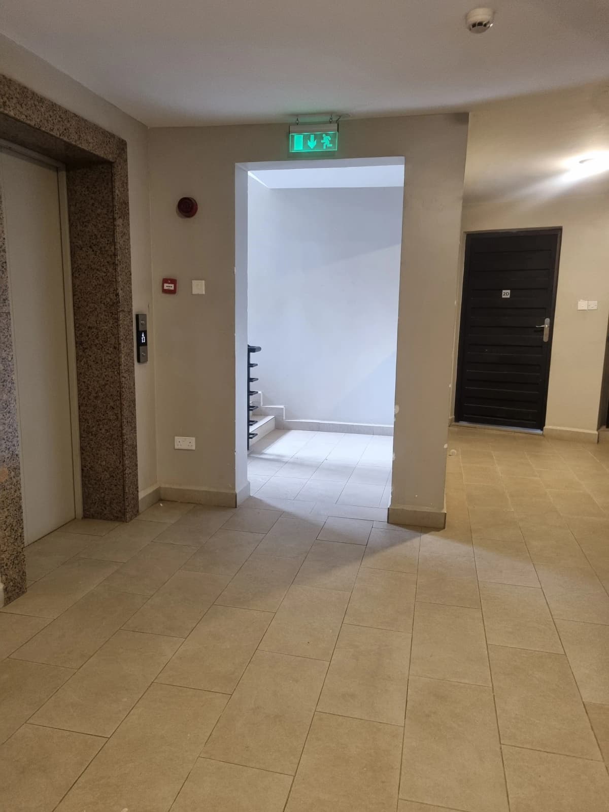 Building lobby with tiled flooring and exit signage