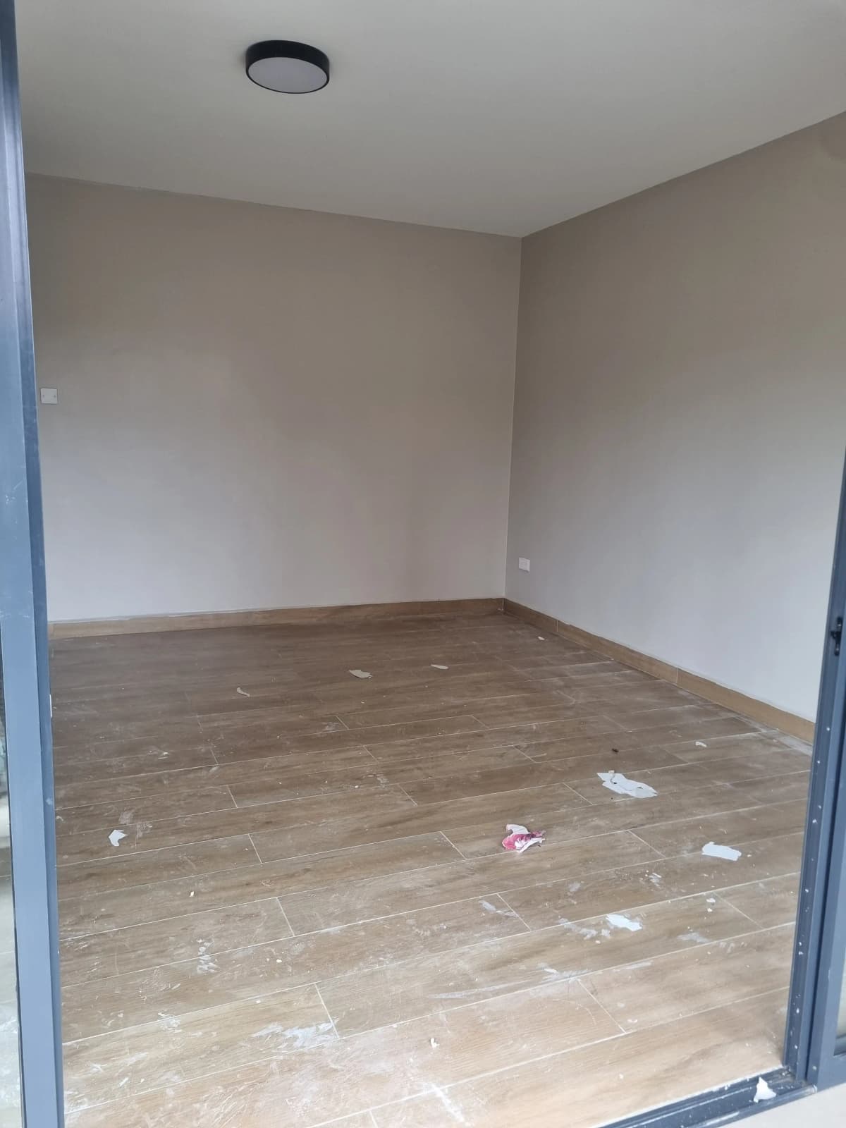 Empty bedroom with wooden flooring and minimal fixtures