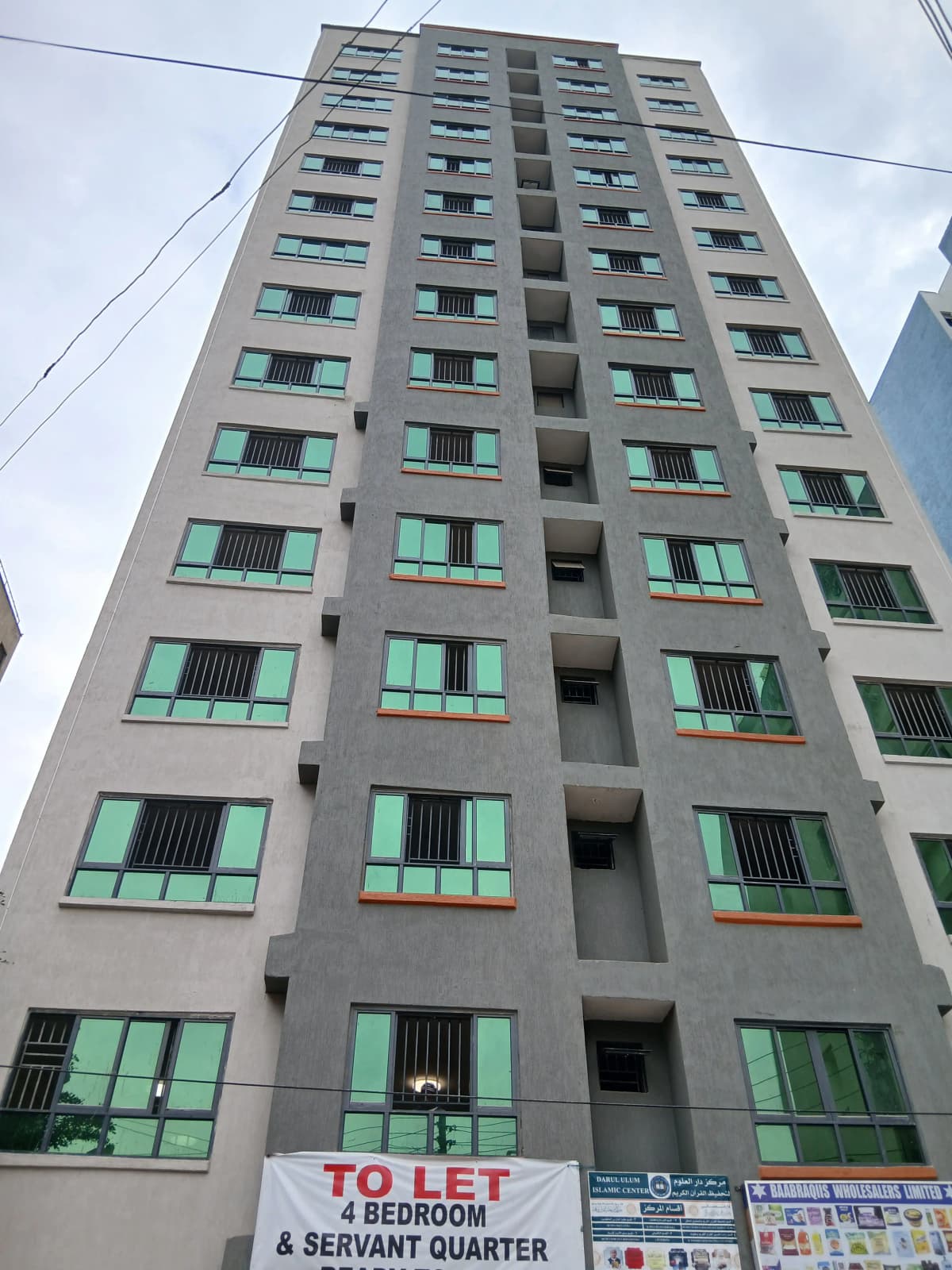 Multi-story residential building facade with green-framed windows