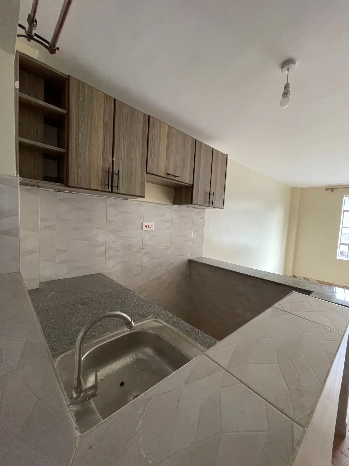 Compact kitchen with dark cabinetry and stainless steel sink