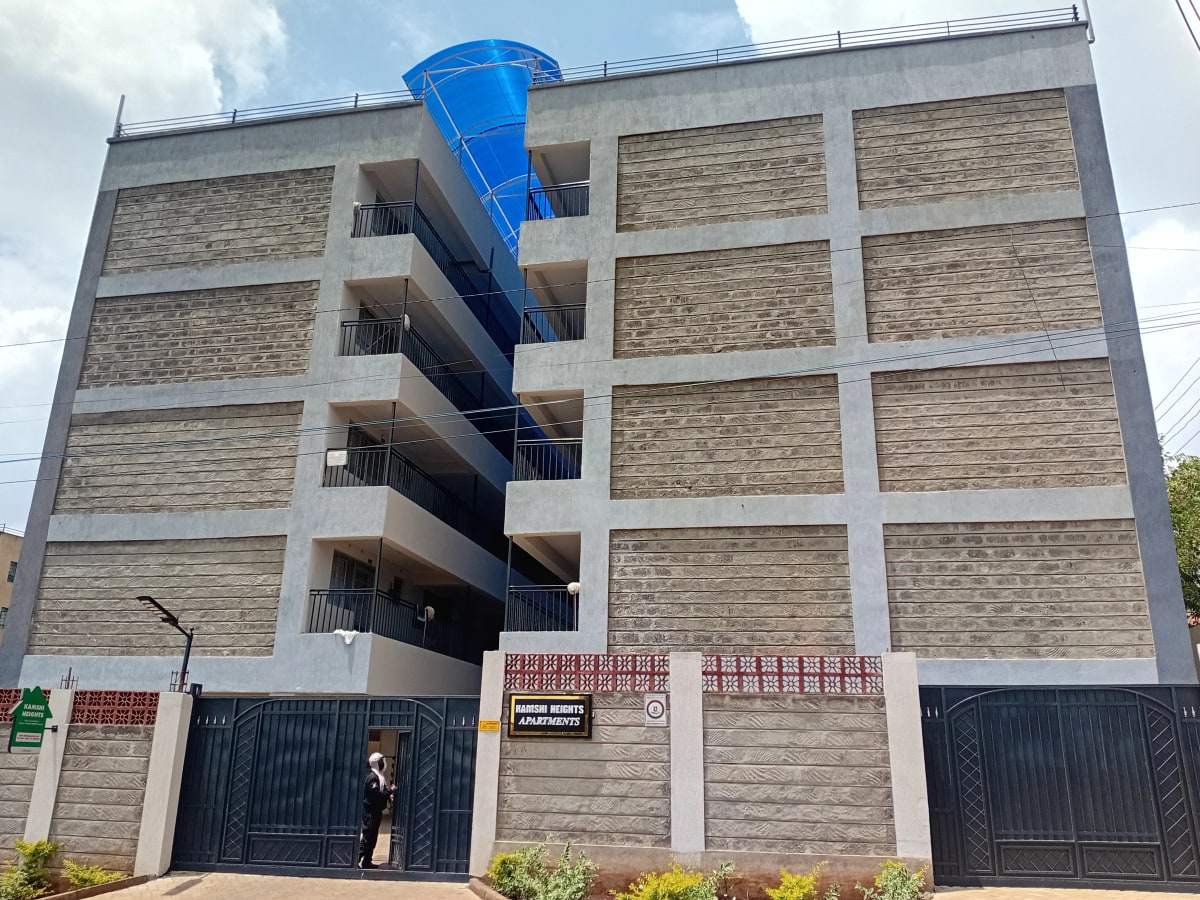 Modern multi-story residential building with brick facade and balconies
