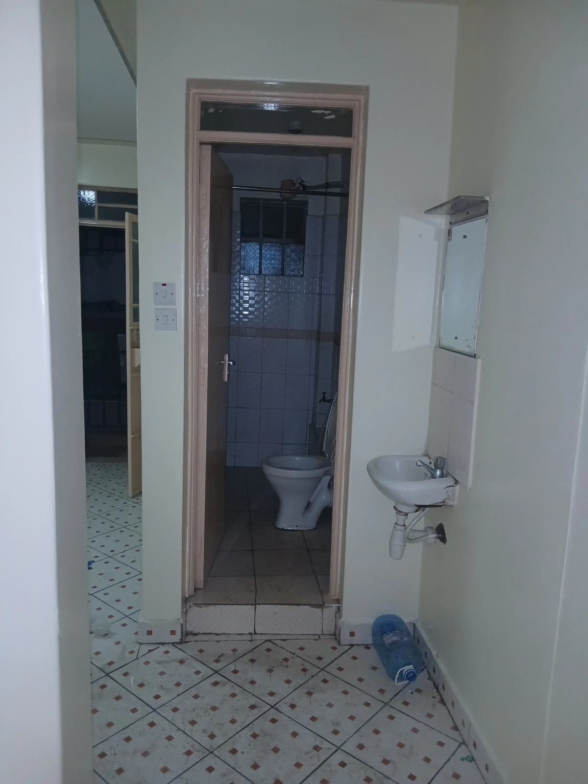 Compact bathroom with toilet, sink, and shower enclosure