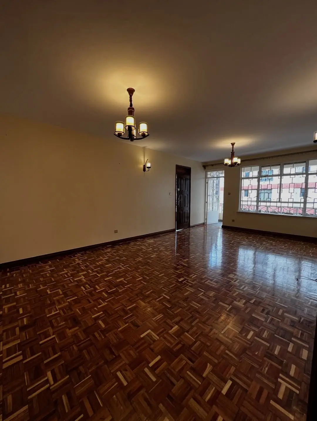 Spacious living room with herringbone parquet flooring and natural light