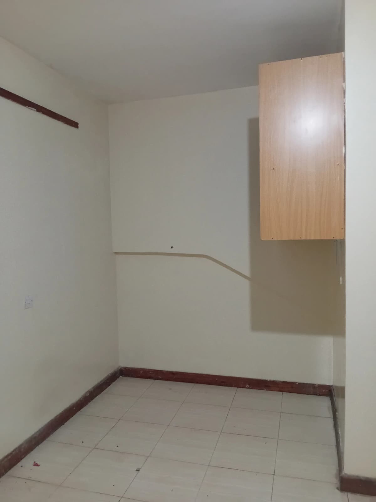 Unfurnished room with wooden built-in cabinet and tiled floor