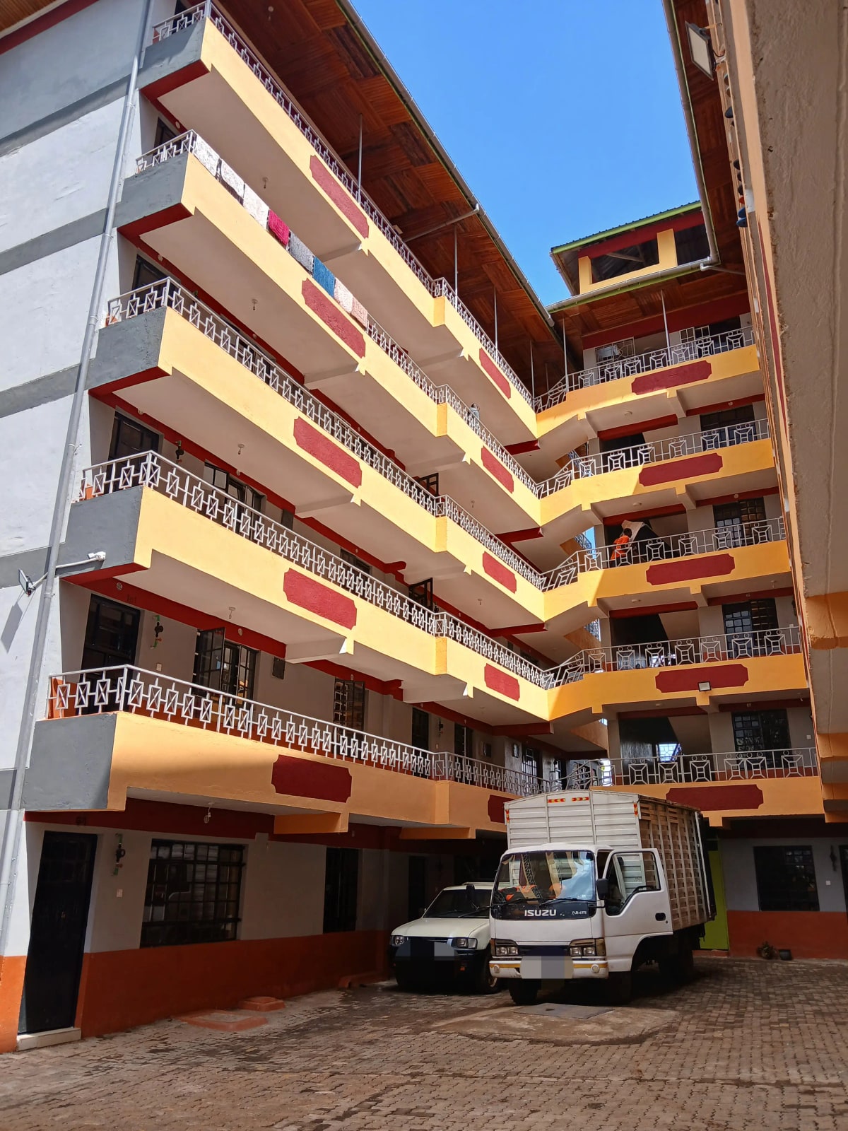 Multi-story residential building with red and yellow facade