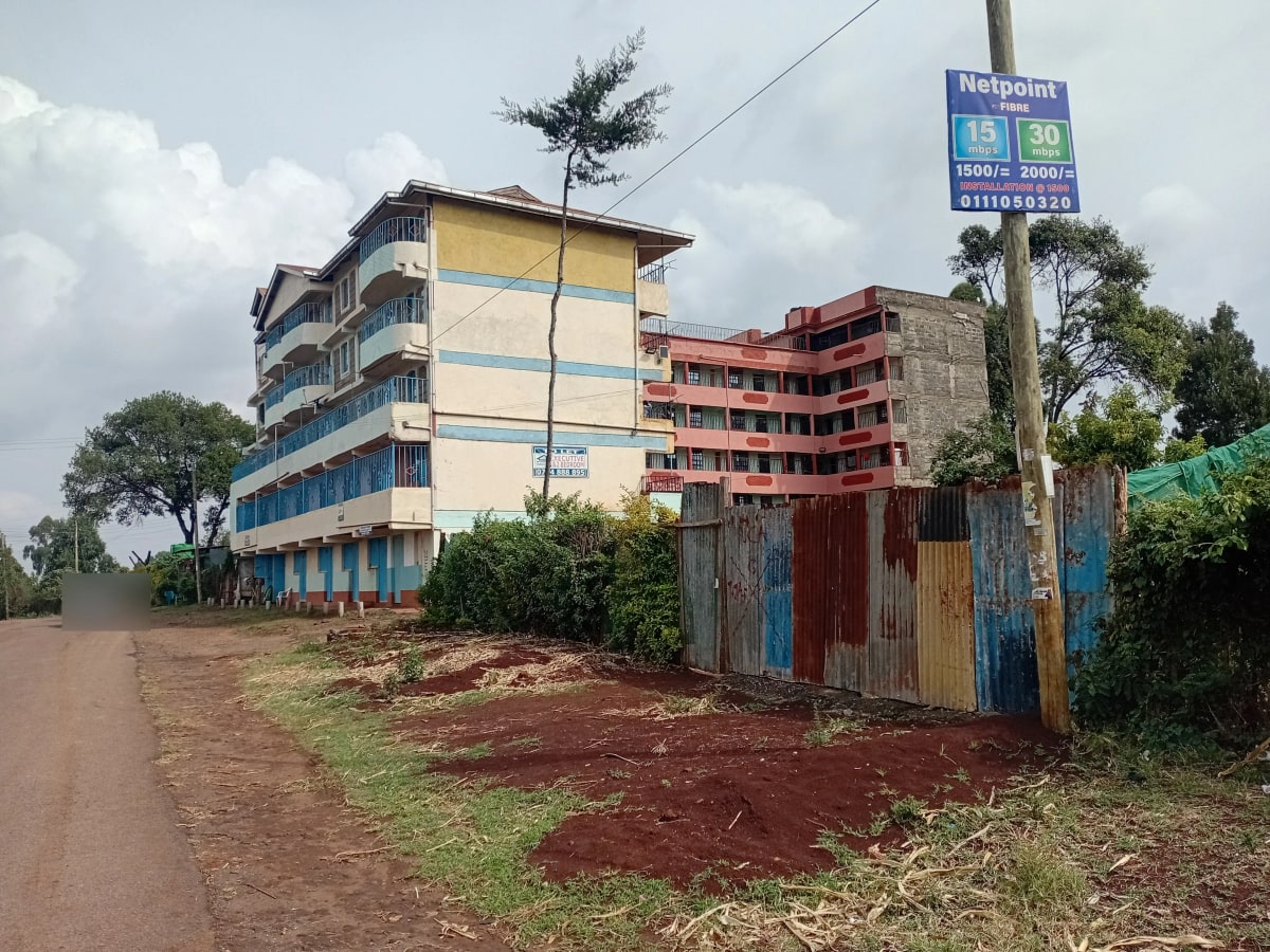 Multi-story residential building with compound entrance and driveway
